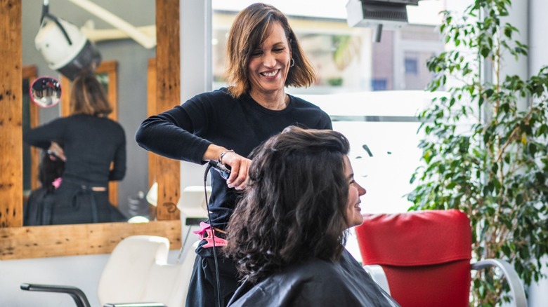 A woman in the salon with her hair stylist