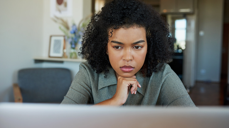 Confused woman looking at the computer