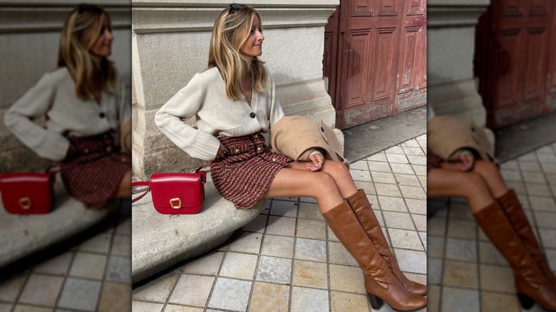 A woman wearing a short tweed skirt and brown boots outside while seated