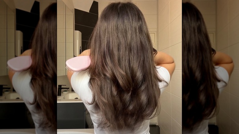 A woman with long, glossy brunette hair