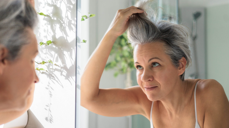 A woman running her fingers through gray hair