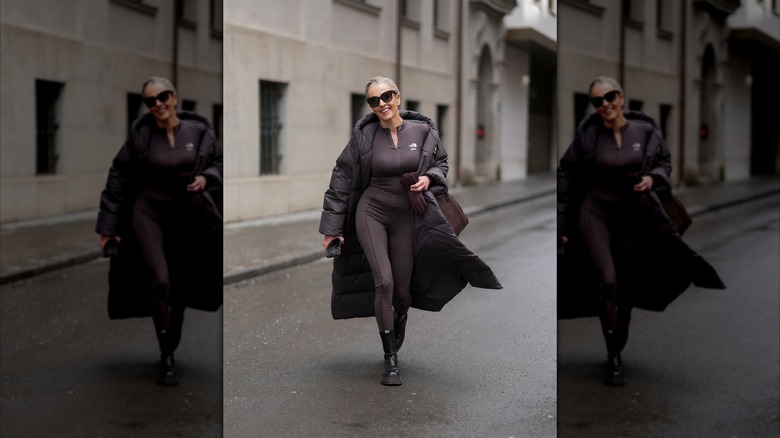 An older woman walking in the street wearing all black