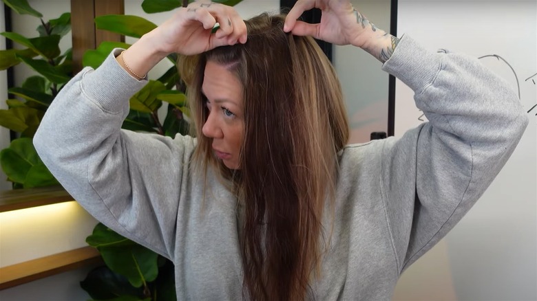 A woman installing clip-in hair extensions
