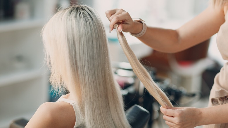 A woman having hair extensions installed