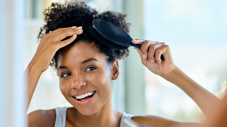 Woman brushing hair with hair brush