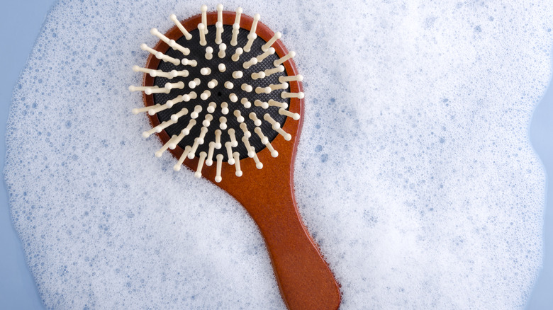 Woman removing hair from brush