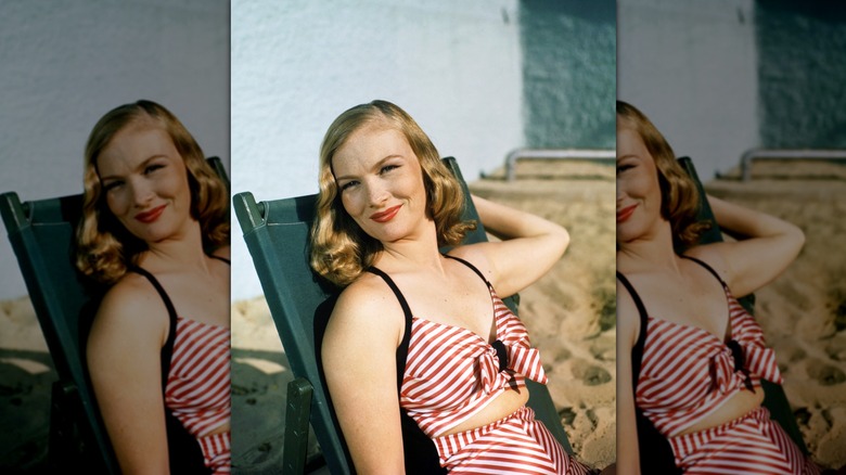 Veronica Lake smiles wearing a striped bikini and hollywood waves