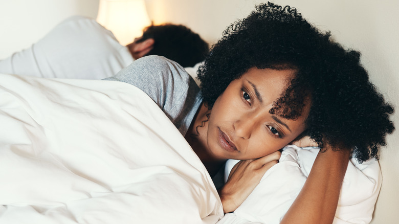 woman sad in bed