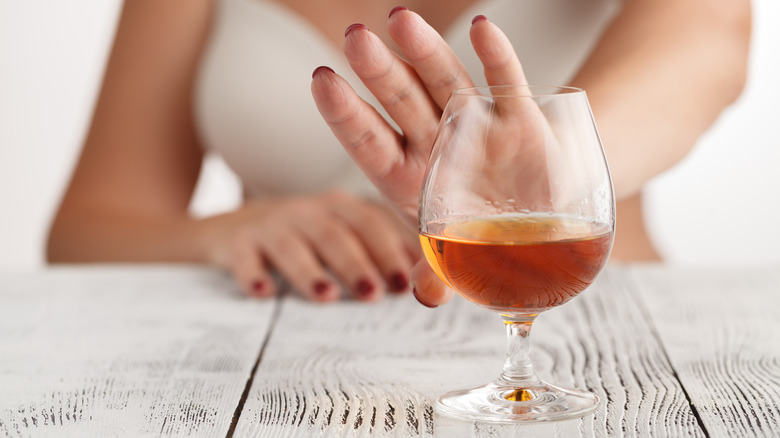 woman pushing away wine