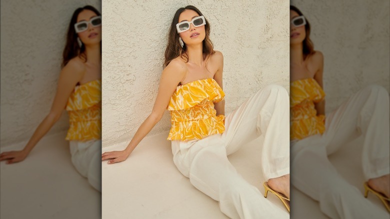 Woman in a crop top and white pants 