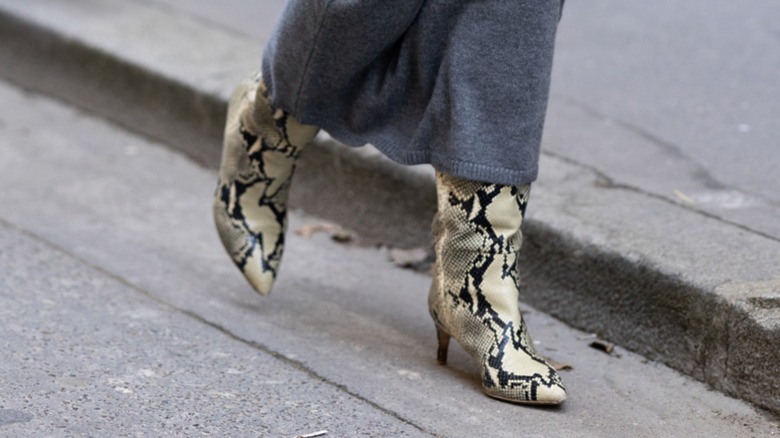 A woman wearing snakeskin boots