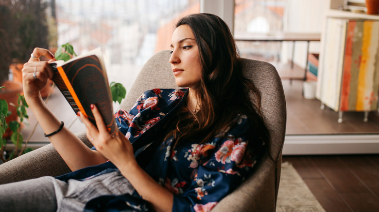 Dark haired woman relaxing while reading a book