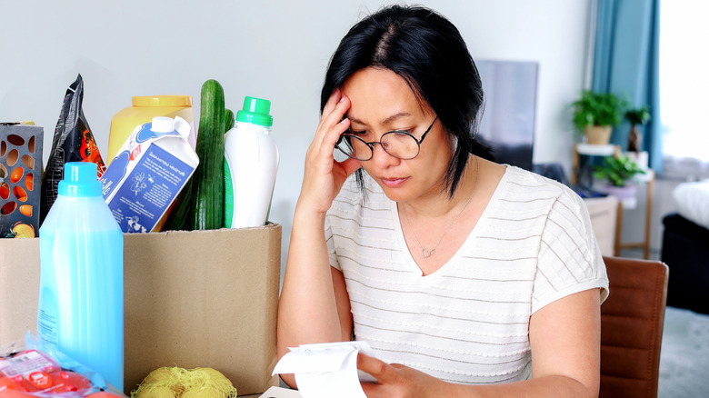 Stressed woman holding receipts