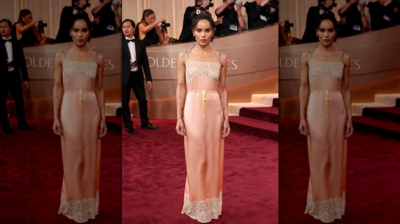 Zoe Kravitz on the red carpet in a pink silk slip dress with lace accents