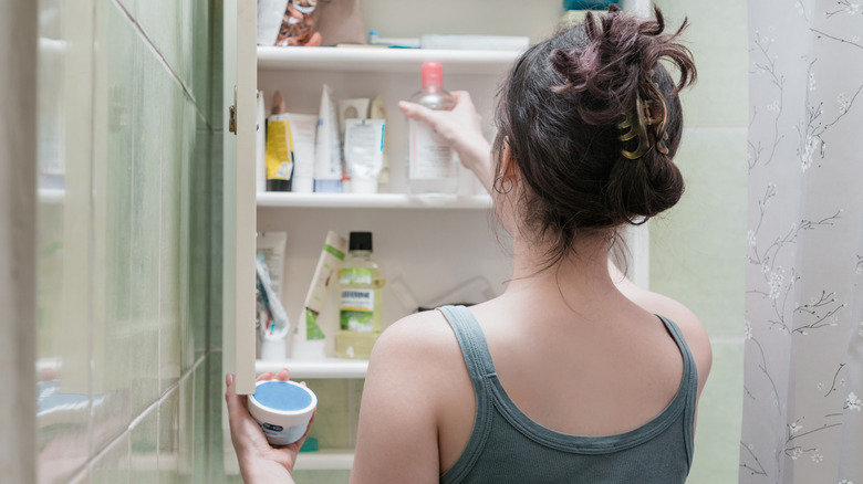 Woman looking in her medicine cabinet