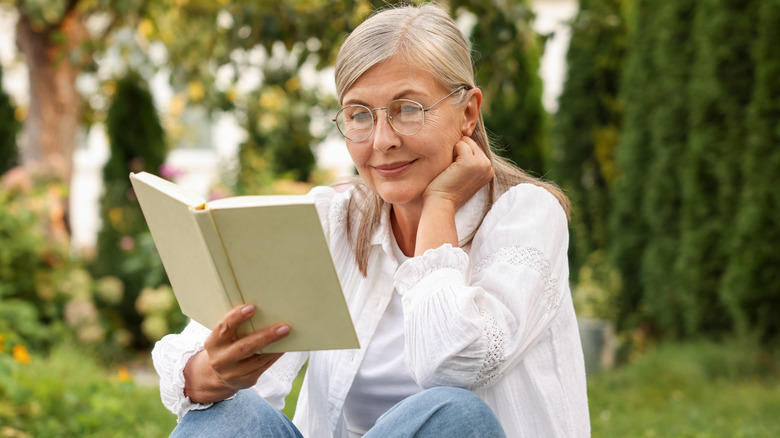 Senior woman reading book in a garden