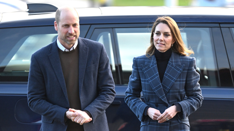 Prince William and Kate Middleton exiting an SUV in blue coats