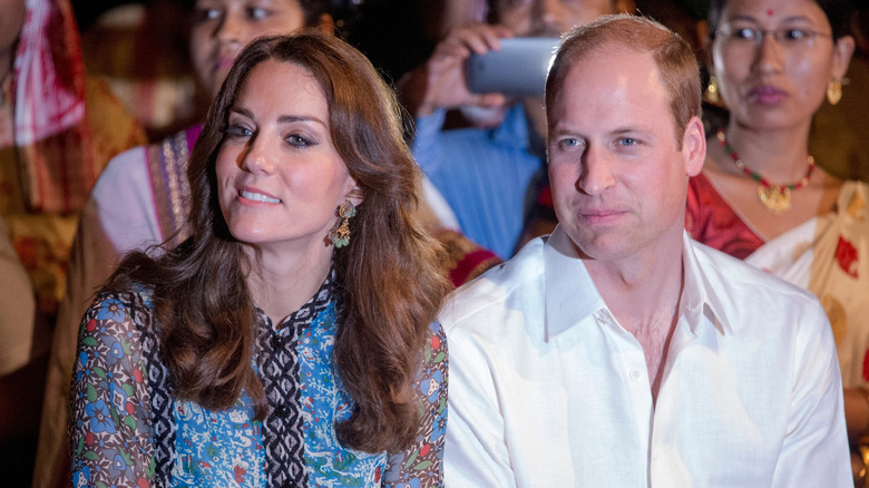 Kate Middleton in a blue dress and sitting next to Prince William
