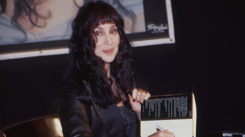 Cher signing a book
