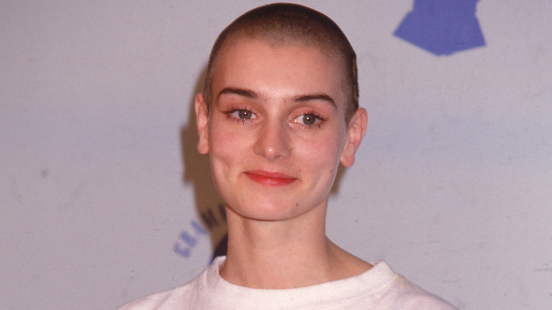 Sinéad O'Connor with a shaved head in a white shirt