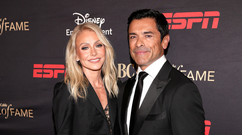 Kelly Ripa and Mark Consuelos posing together on a red carpet in 2025