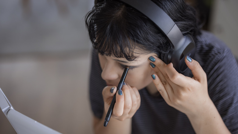 Woman applying eyeliner
