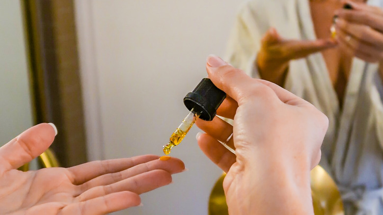 Woman putting oil in her hand