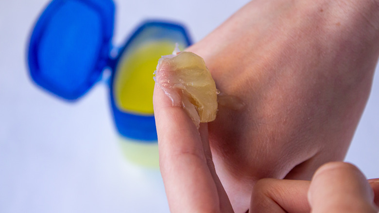Person putting Vaseline on their hand