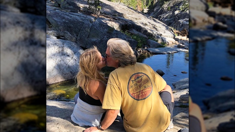 Kurt Russell and Goldie Hawn kissing by the creek