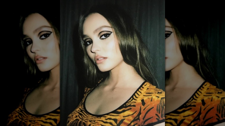 Lily-Rose Depp posing at an angle while wearing '60s inspired eye makeup