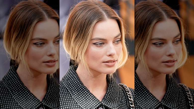 Close-up of Margot Robbie attending a Paris Fashion Week show while wearing a negative space eyeliner look