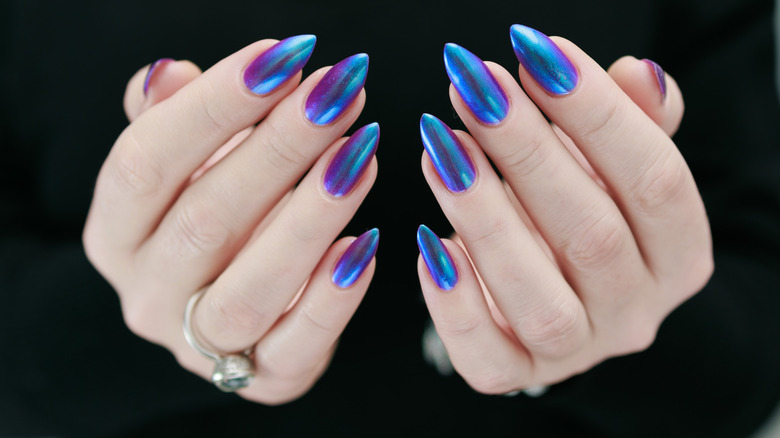 Hands with a blue and purple chrome manicure