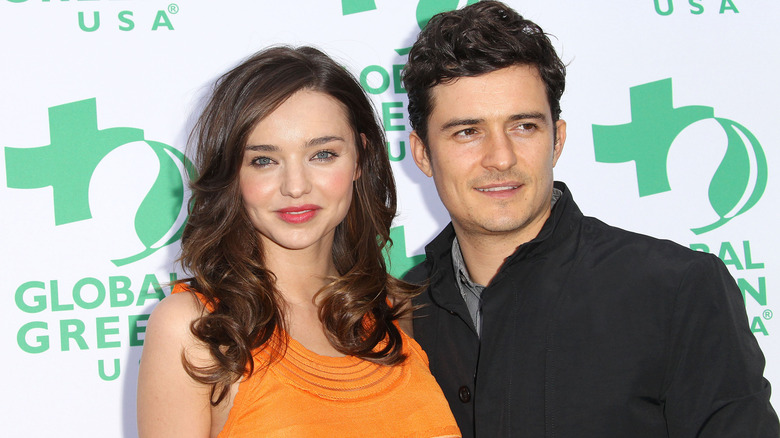 Miranda Kerr and Orlando Bloom smiling on the red carpet in 2011