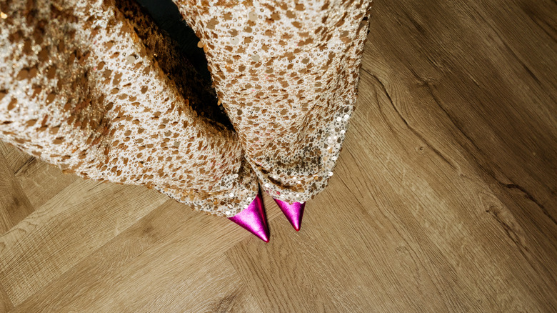 Woman wears gold sequin pants with pink pointed-toe heels