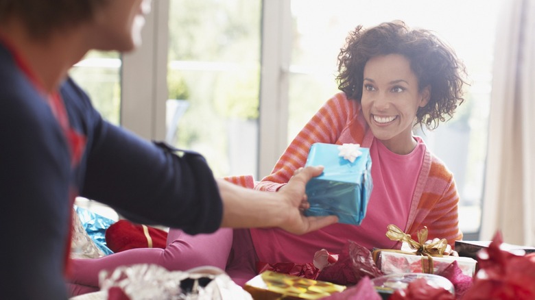 A woman being handed a birthday gift