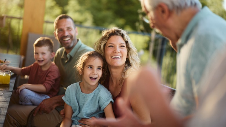 A family of multiple generations smiling together while sitting outside