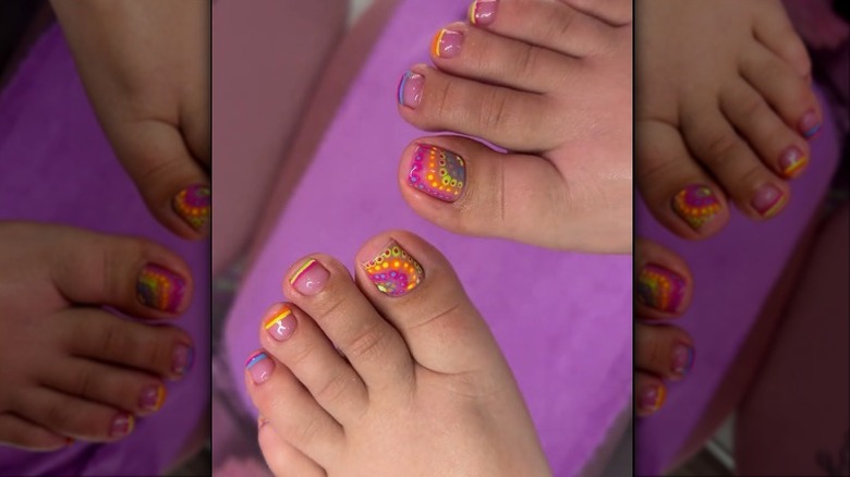 Colorful french tip nails with a tie-dye design on the big toe