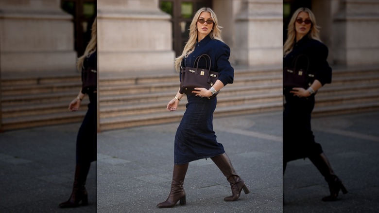 A woman in a denim skirt suit with brown boots