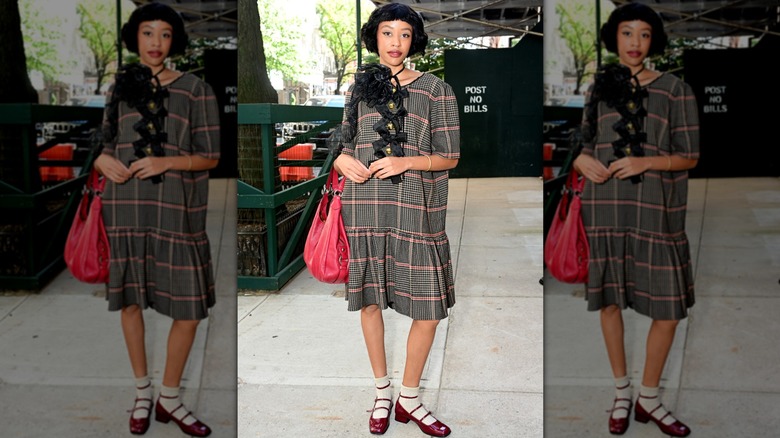 A woman wearing Mary Jane shoes and a plaid dress