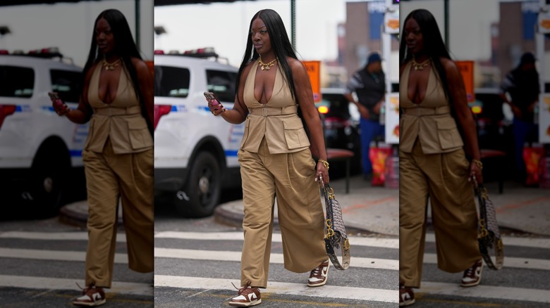 A woman wearing a beige outfit with chocolate brown and white sneakers