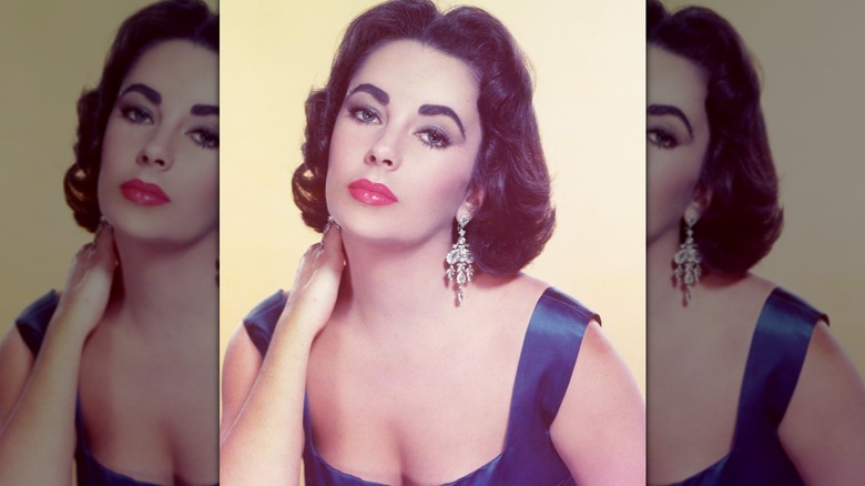Vintage snapshot of Elizabeth Taylor gazing into the camera with one hand on her neck