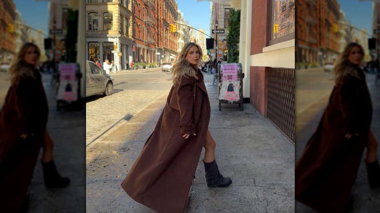 Sophia Tuxford wearing a brown long coat with slouchy brown boots