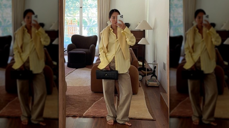Aimee Song wearing a butter yellow shirt with beige wide-leg trousers.