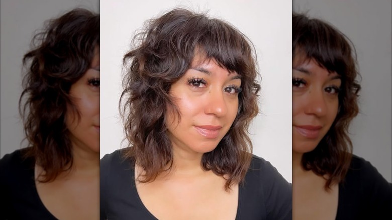 A woman with curly, shoulder-length dark hair