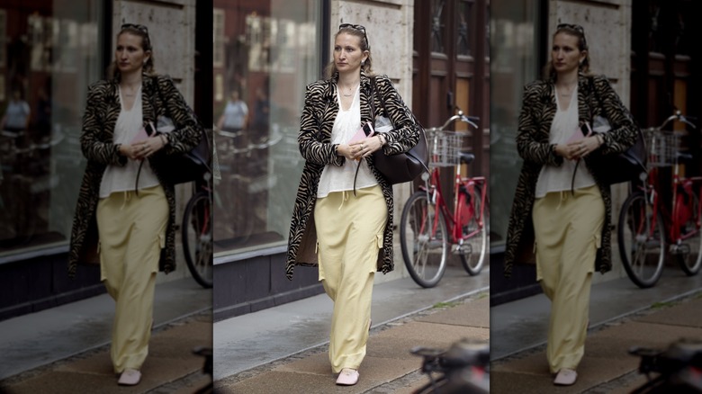 Woman in butter yellow trousers and zebra print jacket
