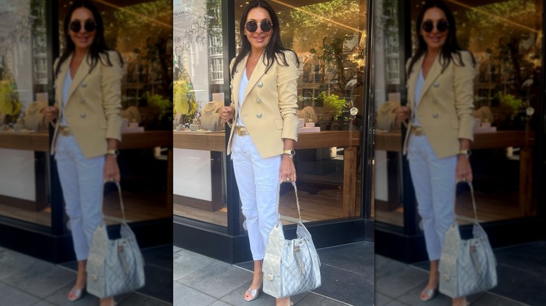 Woman in butter yellow blazer with silver buttons wearing a silver bag and accessories