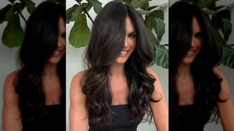 A woman looking at the camera with dark brown hair that's neatly curled