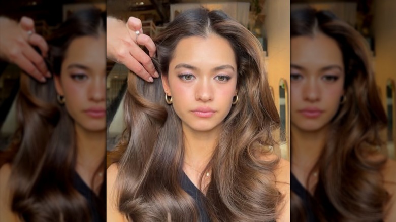 A woman with honey brown hair being styled