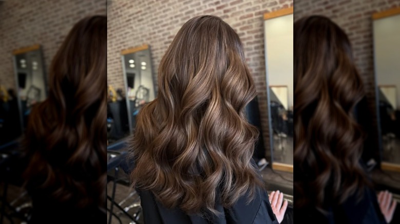 A view from behind of a woman with curled brunette hair