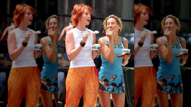 Carrie Bradshaw and Miranda Hobbes walking down a New York street while eating ice cream